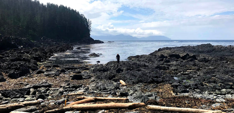 A KEEN employee standing in marine debris in Alaska.