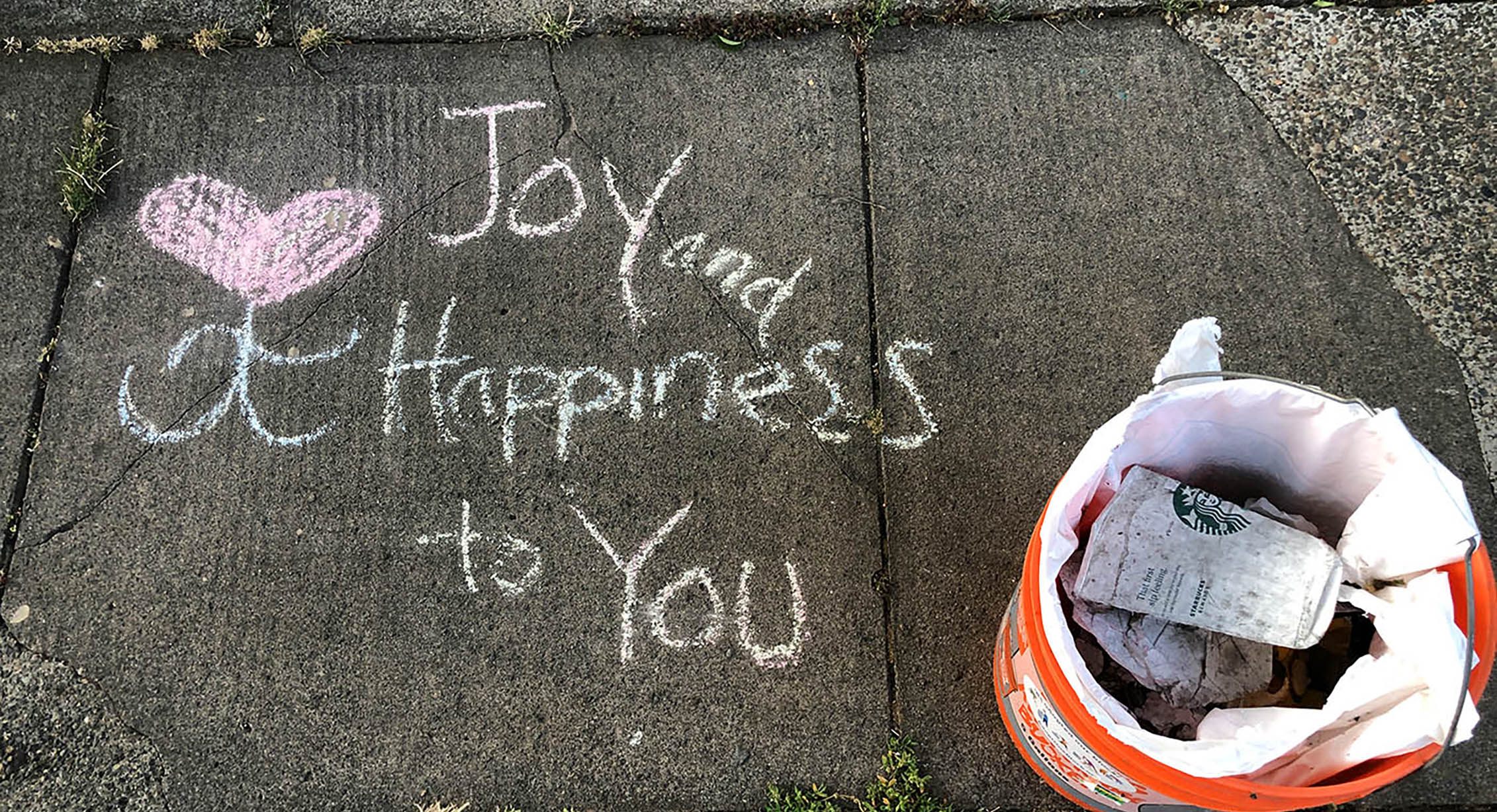 Sidewalk art next to a bucket of litter